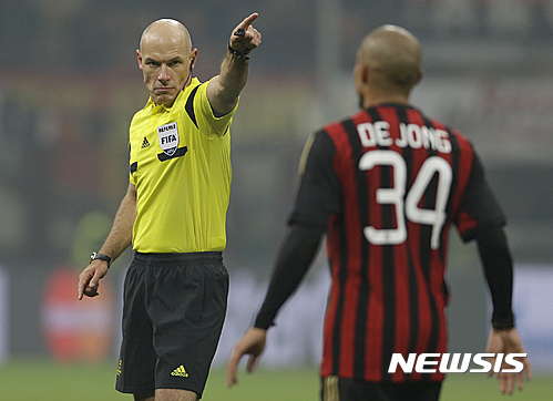 FILE - In this Wednesday, Dec.11, 2013 file photo, referee Howard Webb gestures to AC Milan midfielder Nigel de Jong during a Champions League, Group H, soccer match between AC Milan and Ajax at the San Siro stadium, in Milan, Italy. Moments before the start of the most game of his life, Webb had been struck down by another bout of Obsessive compulsive disorder, a condition in which a person has obsessive thoughts and compulsive behavior. Webb kept the condition secret throughout a career that saw him referee the Champions League final and World Cup final in the same year, 2010, fearing the harsh world of soccer would mark him down as mentally unsound. (AP Photo/Luca Bruno, file)
