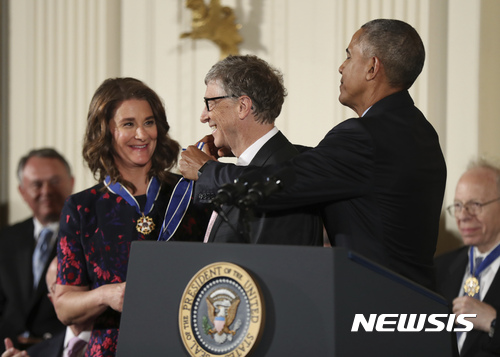 【워싱턴=AP/뉴시스】버락 오바마 미국 대통령(오른쪽)이 22일(현지시간) 워싱턴 백악관 이스트룸에서 임기 마지막 '대통령 자유메달'을 마이크로 소프트 설립자이자 사회운동가인 빌 게이츠에 수여하고 있다. 왼쪽은 빌 게이츠의 부인 멜린다 게이츠이다. 2016.11.23 