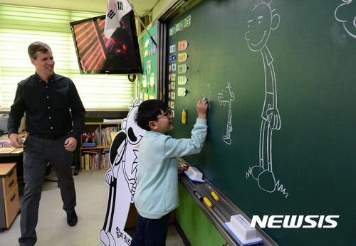 【서울=뉴시스】조성봉 기자 = 13일 오후 서울 종로구 혜화초등학교 3-3반 교실에서 일일교사로 나선 어린이책 시리즈 ‘윔피 키드’ 의 저자 제프 키니가 학생이 그림 그리는 모습을 보며 미소를 짓고 있다. 2016.12.13. suncho21@newsis.com