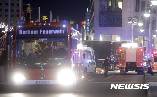 Police stand in front of a truck which ran into a crowded Christmas market killing several people in Berlin, Germany, Monday, Dec. 19, 2016. (AP Photo/Markus Schreiber)