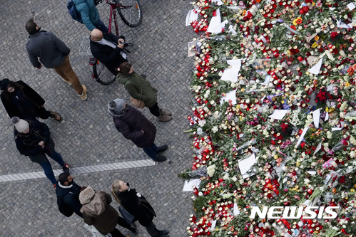 【베를린=AP/뉴시스】독일 수도 베를린의 크리스마스 시장이 트럭 테러 사흘 만인 22일(현지시간) 다시 문을 열었다. 사진은 시민들이 시장 한켠에 마련된 추모의 장소에서 테러 희생자들을 기리는 모습. 2016.12.22.