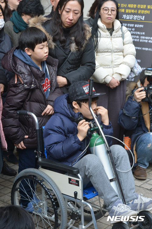 【서울=뉴시스】이영환 기자 = 가습기 살균제 사망 사건과 관련해 1심 선고공판이 열린 6일 오후 서울 서초구 서울중앙지방법원에서 재판을 참관한 피해자 가족들이 기자회견을 하는 가운데 피해자 임성준군(휠체어)이 어두운 표정을 짓고 있다. 가습기 살균제 사망사건이 발생한지 약 5년 반 만에 내려진 첫 판결에서 서울중앙지법 형사합의28부(부장판사 최창영)는 6일 업무상과실치사·상 등 혐의로 기소된 신 전 대표에게 징역 7년을 선고했으며 존 리 전 대표에게는 증거 부족 등을 이유로 무죄를 선고했다. 2017.01.06.  20hwan@newsis.com