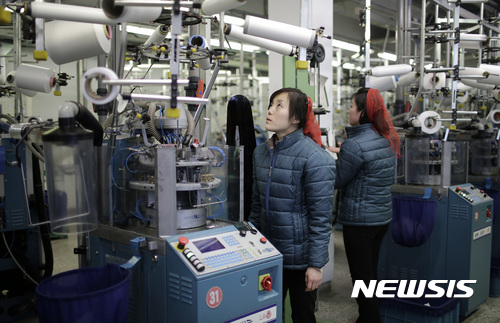 【평양=AP/뉴시스】9일 북한 평양의 양말 공장에서 여성들이 스타킹 기계를 만지고 있다. 2017. 1. 9.  