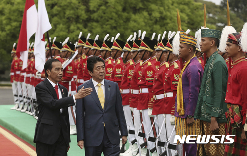 【보고르=AP/뉴시스】인도네시아를 공식 방문한 아베 신조 일본 총리가 15일 서자바 주 보고르 대통령궁에서 조코 위도도 대통령의 안내를 받으며 의장대를 사열하고 있다. 2017.01.16