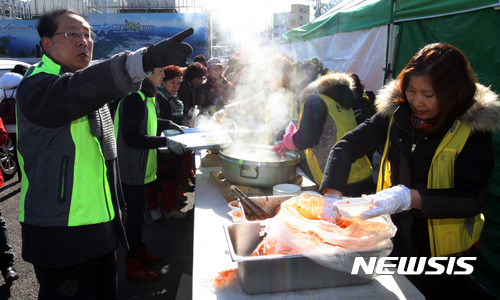 【여수=뉴시스】신대희 기자 = 동여수사회복지관 봉사단이 16일 오후 전남 여수시 교동 여객선터미널 주차장에서 화재로 삶의 터전을 잃은 수산시장 상인들에게 배식 봉사를 하고 있다. 2016.01.16.  sdhdream@newsis.com 