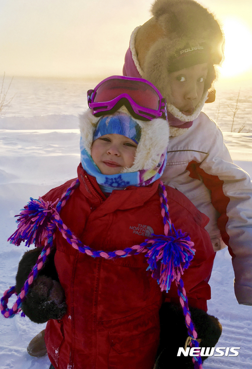 【AP/뉴시스】 = 알래스카주에 5년만의 최악의 한파가 밀려닥치면서 기온이 최저 50도 이하로 떨어진 유콘강가에서 얼어붙은 강을 배경으로 사진을 찍는 어린이들.   