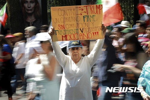【멕시코시티=AP/뉴시스】멕시코 수도 멕시코시티에서 12일(현지시간) 한 여성이 '트럼프 반대'라고 쓴 종이를 들고 시위를 벌이고 있다. 이날 시위에서 약 2만명이 참가했다. 2017.02.13  