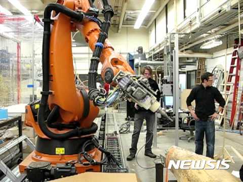 【서울=뉴시스】독일 근로자 2명이 첨단로봇기업 쿠카의 대형 로봇이 작동하는 모습을 지켜보고 있다. 중국의 가전업체 메이디는 작년 말 세계 4대 로봇 제조사인 쿠카 인수를 확정했다. 2017.02.15 
