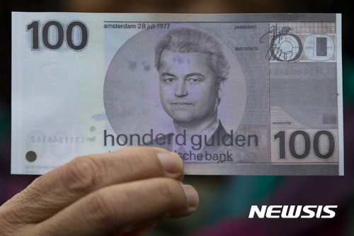【스페이케니서(네덜란드)=AP/뉴시스】네덜란드 극우 자유당의 헤이르트 빌더르스 대표가 18일(현지시간) 스페이케니서에서 총선 유세를 시작한 가운데, 한 지지자가 네덜란드의 옛 지폐인 '길더'를 본떠 그 안에 빌더르스의 얼굴을 그려넣은 가짜 지폐(사진)를 들고 나와 빌더스를 지지했다. 이것은 네덜란드의 유럽연합(EU)에서의 탈퇴를 주장하는 빌더르스를 지지하겠다는 의미다. 2017.02.19.