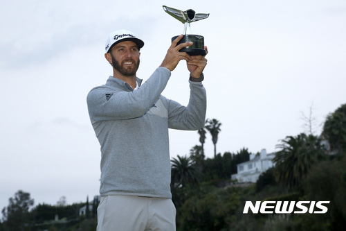 Dustin Johnson poses with his trophy on the 18th green after winning the Genesis Open golf tournament at Riviera Country Club on Sunday, Feb. 19, 2017, in the Pacific Palisades area of Los Angeles. (AP Photo/Ryan Kang)