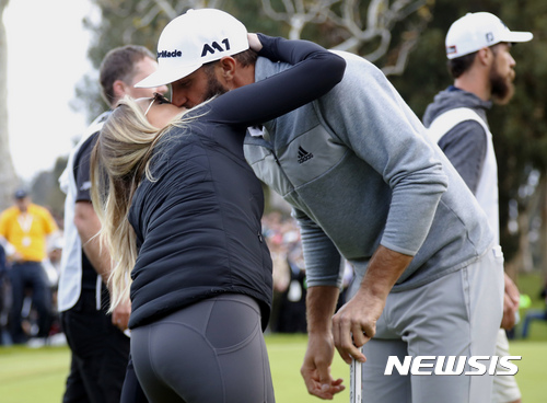 Dustin Johnson kisses his wife Paulina Gretzky on the 18th green after winning the Genesis Open golf tournament at Riviera Country Club on Sunday, Feb. 19, 2017, in the Pacific Palisades area of Los Angeles. (AP Photo/Ryan Kang)