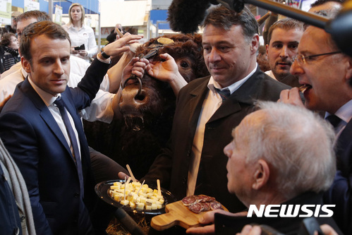 【파리=AP/뉴시스】프랑스의 무소속 대선 후보 엠마뉘엘 마크롱이 1일 파리 농업 전람회에서 유세하는 동안 농부들로부터 치즈와 소시지를 대접받고 있다. 마크롱은 사회당 정부 경제장관을 지냈다. 2017. 3. 1.  