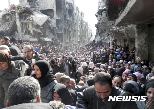【AP/뉴시스】2014년 1월 자료사진으로, 시리아 수도 다마스쿠스 내에서 정부군에 포위된 야르무크 팔레스타인 난민 캠프 주민들이 밥을 얻기 위해 줄을 서 있는 모습이다. 인권의사회는 14일 시리아 정부군이 포위된 곳에 대한 구호를 막아 수많은 주민들을 서서히 살해했다고 유엔에서 주장했다. 2017. 3. 14.  