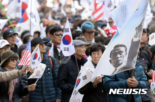 【서울=뉴시스】임태훈 기자 = 18일 오후 서울 중구 대한문 앞에서 열린 보수단체 국민저항본부 대규모집회에서 참석자들이 탄핵 선고 당일 시위 중 사망한 故 김 모씨 외 2명의 추모행사를 마치고 안국역 방향으로 행진하고 있다. 2017.03.18.  taehoonlim@newsis.com