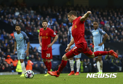 Liverpool's James Milner scores the opening goal from the penalty spot during the English Premier League soccer match between Manchester City and Liverpool at the Etihad Stadium in Manchester, England, Sunday March 19, 2017. (AP Photo/Dave Thompson)