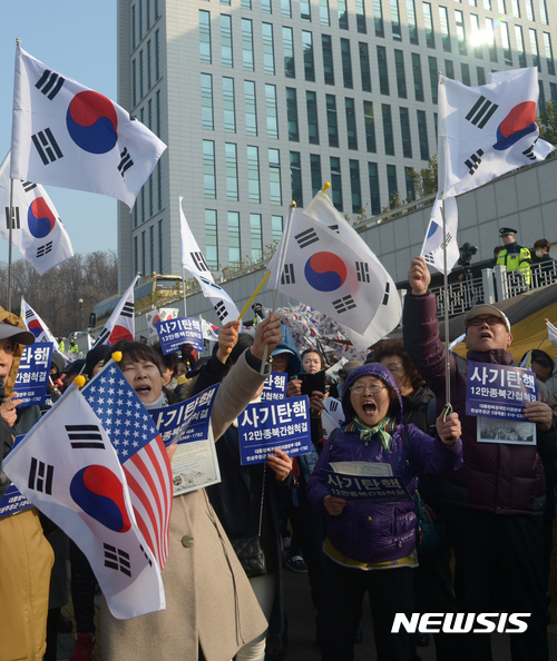 【서울=뉴시스】조수정 기자 = 박근혜 전 대통령이 검찰 조사를 받기 위해 출두한 21일 오전 서울 서초동 중앙지검 청사 앞에서 대통령복권국민저항본부 회원들이 태극기를 흔들며 집회를 하고 있다. 2017.03.21.  chocrystal@newsis.com