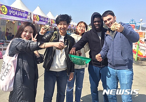 【대전=뉴시스】유순상 기자 = 배재대 한국어교육원이 21일 충남 서천에서 외국인 유학생을 대상으로 실시한 지역문화탐방에서 참가자들이 주꾸미를 들어보이고 기념촬영을 하고 있다.2017.03.21.(사진=배재대 제공)  ssyoo@newsis.com