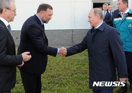 【AP/뉴시스】2014년 9월 자료사진으로, 블라디미르 푸틴 러시아 대통령이 코스토보 소재 비닐 공장을 방문해 러시아 알루미늄 재벌 올레그 데리파스카(왼쪽)와 악수하고 있다.2022.09.30