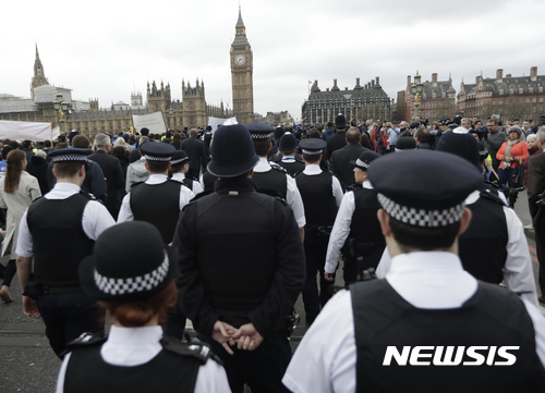 【런던=AP/뉴시스】29일(현지시간) 영국 런던 테러 일주일을 맞아 사건이 발생한 웨스트민스터 다리에서 추모 행사가 진행되고 있다. 사진은 경찰관들이 이날 행사에서 순직한 동료 키스 파머를 추모하는 모습. 2017.3.30