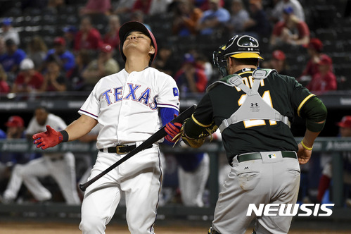 Texas Rangers designated hitter Shin-Soo Choo reacts after striking out as he is tagged by Oakland Athletics catcher Stephen Vogt in the ninth inning of a baseball game, Saturday, April 8, 2017, in Arlington, Texas. (AP Photo/Jeffrey McWhorter)
