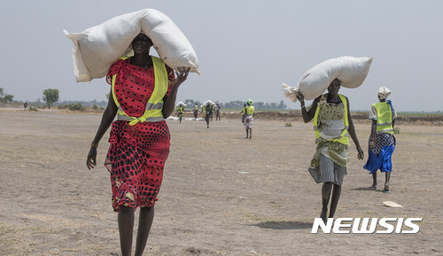 【레어=AP/뉴시스】11일 남수단 마을에서 국제 구호단체로부터 식량을 배급 받은 여인들이 집으로 가고 있다. 아프리카 북부는 가뭄으로 기아 위기에 몰려 있다. 2017. 4. 12.