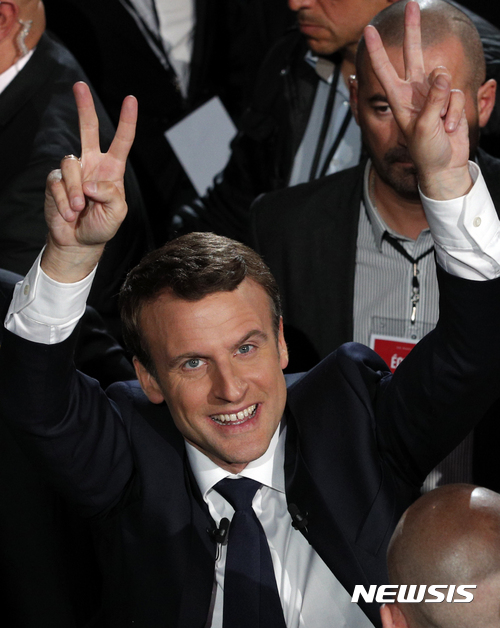 【파리=AP/뉴시스】에마뉘엘 마크롱 프랑스 대선후보가 17일(현지시간) 파리에서 회의를 마치고 나오면서 지지자들을 향해 손가락으로 승리의 브이(V)자를 만들어 보이고 있다. 2017.04.18 