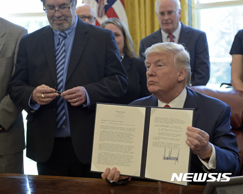 【워싱턴=AP/뉴시스】도널드 트럼프 미국 대통령이 20일(현지시간) 백악관에서 철강제품 수입 제한 여부를 조사하기 위한 행정명령에 서명했다. 2017.4.21. 