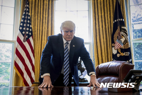 President Donald Trump poses for a portrait in the Oval Office in Washington, Friday, April 21, 2017. With his tweets and his bravado, Trump is putting his mark on the presidency in his first 100 days in office. He's flouted conventions of the institution by holding on to his business, hiring family members as advisers and refusing to release his tax returns. He's tested conventional political wisdom by eschewing travel, church, transparency, discipline, consistency and decorum. But the presidency is also having an impact on Trump, prompting him, at times, to play the role of traditional president. (AP Photo/Andrew Harnik)
