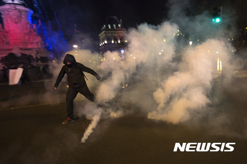 【파리=AP/뉴시스】23일(현지시간) 프랑스 파리에서 1차 대선 결과에 항의하던 시위자가 경찰의 최루 가스를 피하고 있다. 2017.4.24. 