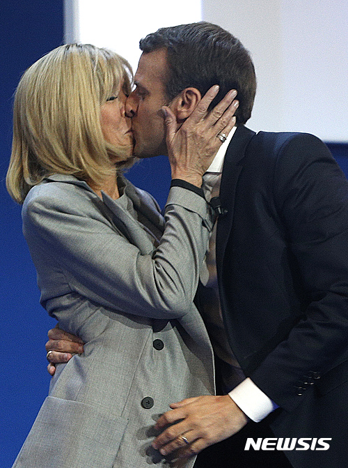 프랑스 중도 대선 후보 에마뉘엘 마크롱 전 경제장관이 23일(현지시간) 파리에서 아내 브리짓 트로뉴와 결선 진출을 축하하고 있다. <파리=AP/뉴시스>