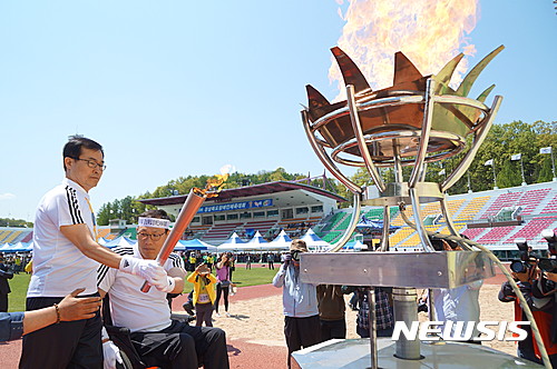 【안동=뉴시스】김진호 기자 = 27일 경북 안동시민운동장에서 열린 제19회 경상북도장애인체육대회에서 성화 봉송 최종주자로 나선 김성진 안동시의회 의장과 홍성직 안동시 장애인탁구협회장이 성화대에 점화하고 있다.2017.04.27  kjh9326@newsis.com