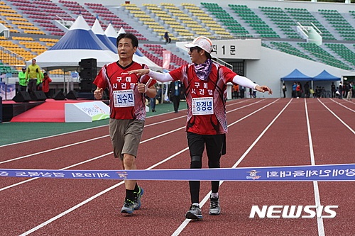 【안동=뉴시스】김진호 기자 = 27일 경북 안동시민운동장에서 열린 제19회 경상북도장애인체육대회 5㎞ 마라톤 종목 시각장애인 부문에서 권수진 선수조가 1위로 결승점을 통과하고 있다.2017.04.27  kjh9326@newsis.com