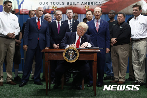 President Donald Trump, joined by Vice President Mike Pence, Secretary of Veterans Affairs David Shulkin, Secretary of Commerce Wilbur Ross, signs an Executive Order on the Establishment of Office of Trade and Manufacturing Policy at The AMES Companies, Inc., in Harrisburg, Pa., Saturday, April, 29, 2017. (AP Photo/Carolyn Kaster)