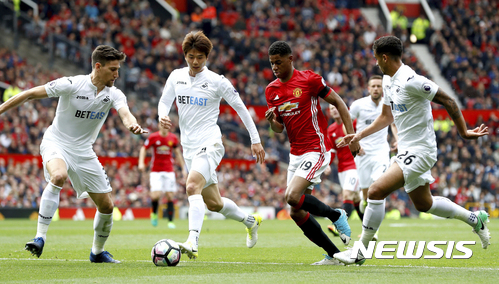 Swansea City's Federico Fernandez, left, and Ki Sung-yueng, second left, crowd Manchester United's Marcus Rashford off the ball, with Swansea City's Kyle Naughton, right, during their English Premier League soccer match at Old Trafford in Manchester, England, Sunday April 30, 2017. (Martin Rickett/PA via AP)