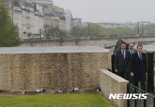 Independent centrist presidential candidate Emmanuel Macron visits the Holocaust memorial in Paris, France, Sunday, April 30, 2017. French presidential candidate Emmanuel Macron is visiting the Holocaust Memorial in Paris with a somber message: Never again. (AP Photo/Michel Euler)