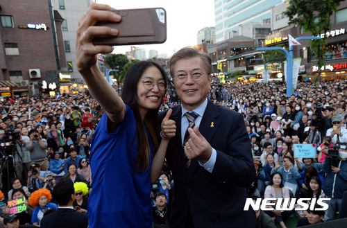 【서울=뉴시스】박영태 기자 = 문재인 더불어민주당 대선후보가 6일 오후 서울 마포구 홍대입구역 걷고 싶은 거리에서 진행된 '투표참여 릴레이 버스킹 vote0509' 캠페인 및 공약이행 프리허그에서 시민과 기념촬영을 하고 있다. 2017.05.06. since1999@newsis.com