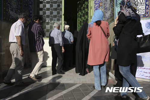 【 테헤란=AP/뉴시스】이란 테헤란에서 19일(현지시가) 유권자들이 대선 및 지방선거에 참여하기 위해 투표소 앞에 줄 서있다. 2017.05.19 