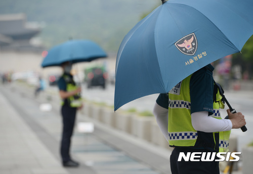 【서울=뉴시스】김진아 기자 = 초여름 더위가 계속되고 있는 22일 서울 종로구 광화문 광장에서 경찰들이 우산을 쓰고 근무를 서고 있다.  기상청은 이날 오후 오존 지수가 '매우 나쁨' 수준으로 급격히 오른고, 자외선 지수도 '나쁨' 수준으로 오르기 때문에 야외 활동을 자제할 필요가 있다고 당부했다. 2017.05.22.  bluesoda@newsis.com 