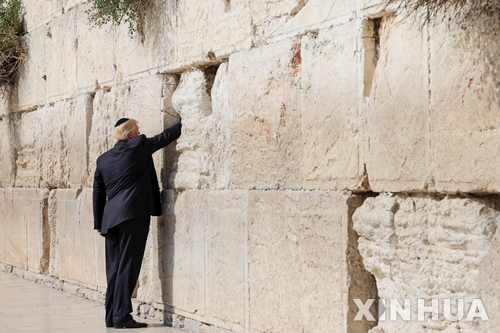 【예루살렘=신화/뉴시스】도널드 트럼프 미국 대통령이 22일(현지시간) 예루살렘 구시가의 유대인 성지 '통곡의 벽'을 방문해 벽의 틈에 손을 넣어보고 있다. 2017.05.23 