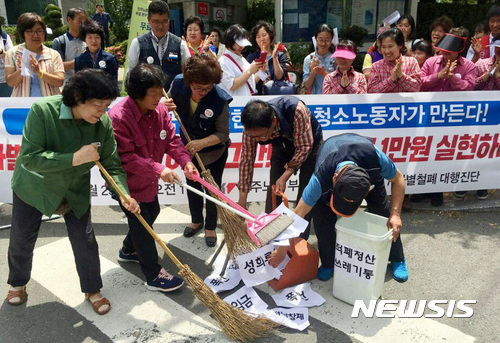 【부산=뉴시스】하경민 기자 = 23일 부산 연제구 부산고용노동청 앞에서 부산지역 청소노동자들이 차별 철폐와 처우 개선, 최저임금 1만원 실현 등을 요구하는 기자회견을 가진 뒤 막말, 폭언, 성희롱 등을 참고 견디는 청소노동자를 쓰레기 취급하는 이 사회를 청소하겠다는 뜻으로 퍼포먼스를 펼치고 있다. 2017.05.23. (사진=민주노총 부산본부 제공)  yulnetphoto@newsis.com