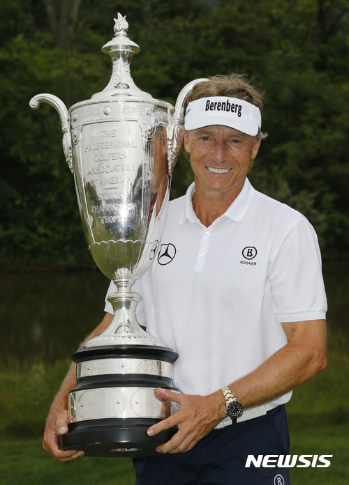 Bernhard Langer, of Germany, hoists the winners trophy as he celebrates wining the Senior PGA Championship at the Trump National golf club in Sterling, Va., Sunday, May 28, 2017. Langer finished the tournament with a one stroke victory at 18-under-par. (AP Photo/Steve Helber)