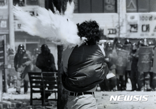 【광주=뉴시스】 1987년 5월 15일 광주 전남대학교에서 일어난 시위 도중 참가 학생의 얼굴 왼편에서 최루탄이 폭발한 모습. (사진=정태원 제공)(* 위 사진은 재배포, 재판매, DB 및 활용을 금지합니다.)photo@newsis.com