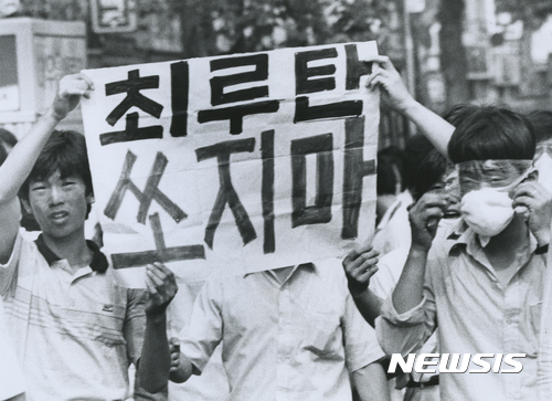 【서울=뉴시스】 1987년 6월 18일 열린 시위현장에서 대학생들이 "최루탄 쏘지마"라고 쓰여진 피켓을 들고 있다. 오른쪽에 있는 학생은 최루가스로부터 얼굴을 보호하기 위해 비닐랩으로 얼굴을 감싸고 있다. (사진=정태원 제공)(* 위 사진은 재배포, 재판매, DB 및 활용을 금지합니다.)photo@newsis.com