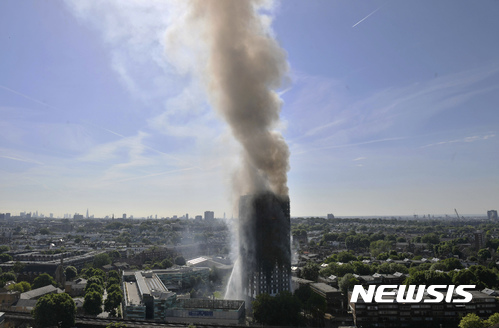 【런던=AP/뉴시스】영국 런던 웨스트 지역의 24층 그렌펠 아파트에서 14일 새벽 화재가 발생해 상부층 전체가 꺼멓게 타 버린 가운데 날이 훤히 밝은 아침에도 연기가 높이 솟아 오르고 있다. 2017. 6. 14.  