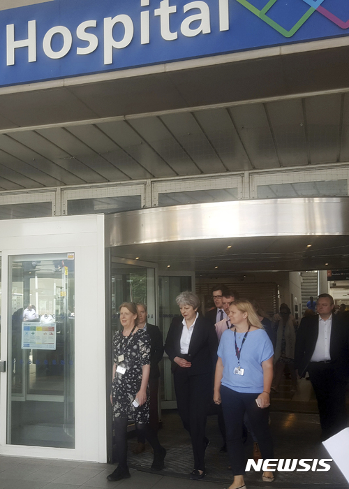 【런던=AP/뉴시스】테리사 메이 영국 총리(가운데)가 16일(현지시간) 런던 그렌펠 타워 화재 부상자들이 입원한 병원을 방문한 뒤 길을 나서고 있다. 2017.6.17. 