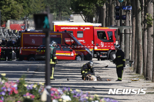 【파리=AP/뉴시스】프랑스 응급대원들이 19일(현지시간) 파리 샹젤리제에서 쓰러진 사람을 살펴보고 있다. 파리  샹젤리제에서 이날 차량이 경찰차로 돌진해 충돌하면서 폭발하는 사건이 발생했다. 현지 경찰은 이날 체포된 용의자는 숨졌다고 밝혔다. 검찰은 이번 사건에 대해 테러 가능성을 두고 조사에 착수했다. 2017.06.20