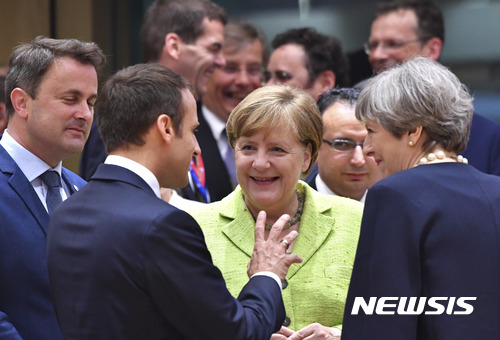 【브뤼셀=AP/뉴시스】22일(현지시간) 벨기에 브뤼셀에서 열린 유럽연합(EU) 정상회의에서 에마뉘엘 마크롱 프랑스 대통령(왼쪽부터), 앙겔라 메르켈 독일 총리, 테리사 메이 영국 총리가 대화를 나누고 있다. 2017.6.23.