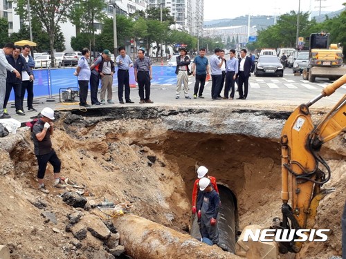 【울산=뉴시스】박일호 기자 = 6월 25일 오전 권명호 동구청장이 울산시 동구 서부동 솔밭삼거리 도로에서 발생한 싱크홀 현장을 방문한 가운데 관계 공무원들이 복구작업을 펼치고 있다. 2017.06.25. (사진=울산 동구 제공) <a href="mailto:photo@newsis.com">photo@newsis.com</a>