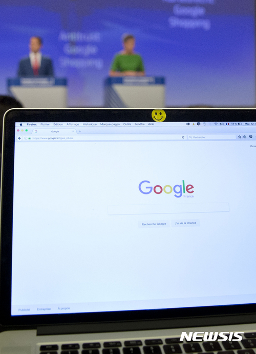 A Google search site is open on the computer of a journalist during a media conference of European Union Commissioner for Competition Margrethe Vestager, right rear, at EU headquarters in Brussels on Tuesday, June 27, 2017. The European Union's competition watchdog has fined internet giant Google over its online shopping service. (AP Photo/Virginia Mayo)