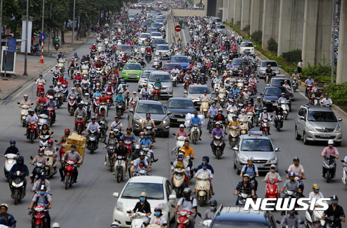 In this June 21, 2017, photo, motorbikes and cars fight for space on a street in Hanoi, Vietnam. Vietnam’s motorbike taxis are seeing their business dry up as customers increasingly opt for ride hailing services like Uber and Grab-Taxi. (AP Photo/Tran Van Minh)